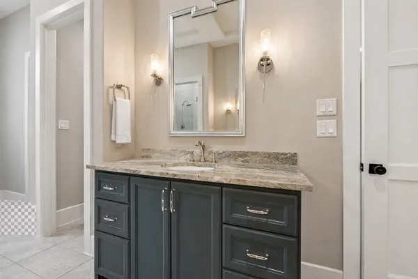 a bathroom with a granite countertop sink and a mirror