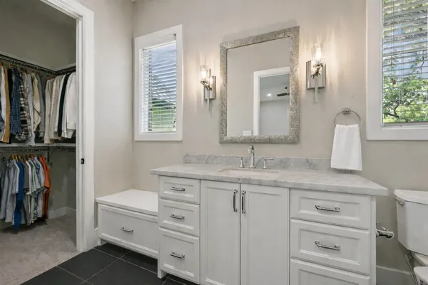 a bathroom with a granite countertop sink a toilet and a mirror