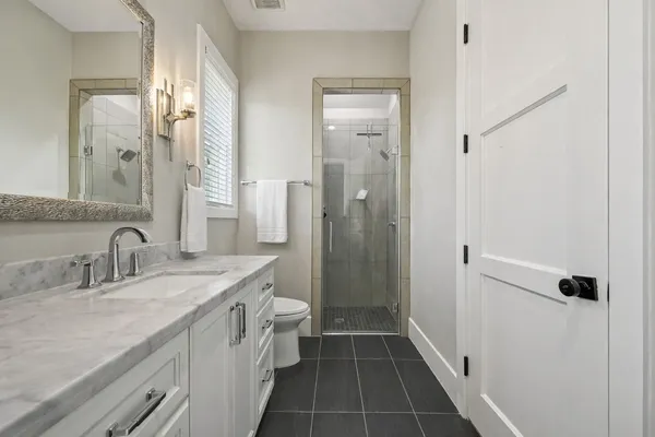 a bathroom with a double vanity sink a mirror and a shower