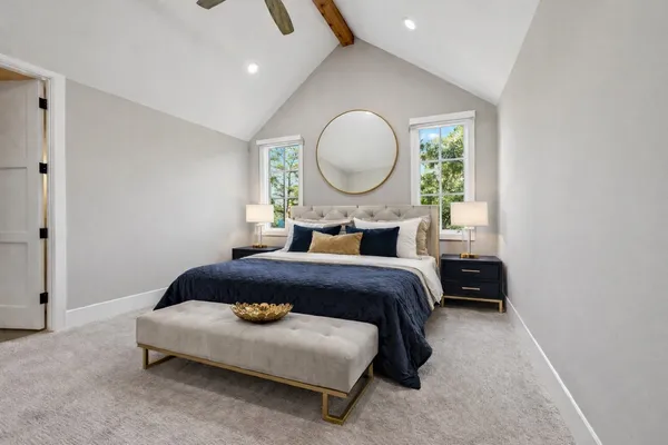 a bedroom with a bed mirror and a window