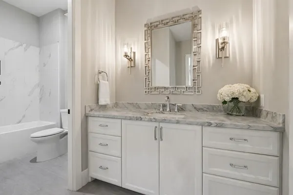 a bathroom with a granite countertop sink and a mirror