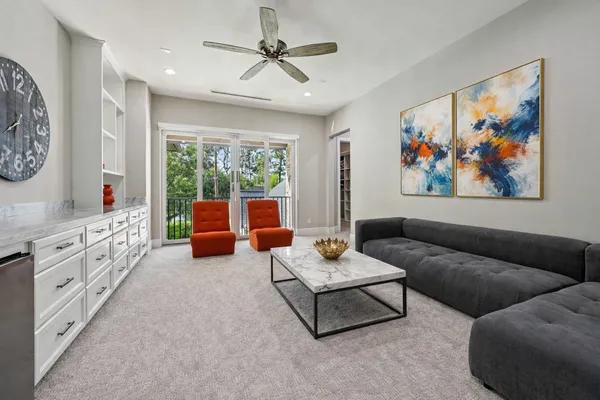 a living room with furniture ceiling fan and a window