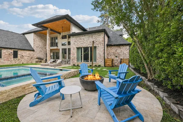 a backyard of a house with barbeque oven table and chairs