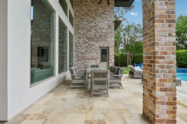 a view of a patio with a table and chairs and potted plants