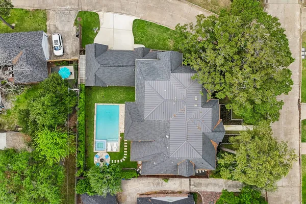 an aerial view of a house with plants and large trees
