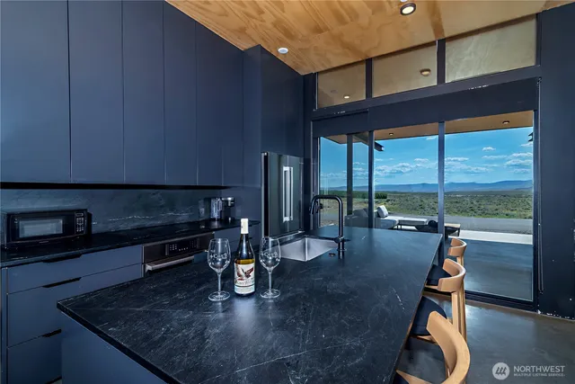 a kitchen with granite countertop a stove a sink and a wooden cabinets