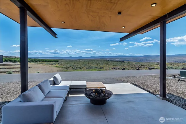 a view of a patio with couches chairs and a floor to ceiling window