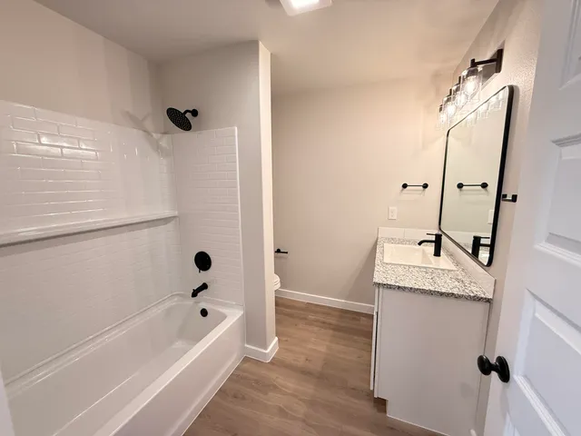 a bathroom with a granite countertop sink toilet and shower