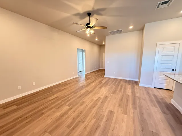 a view of a room with wooden floor and ceiling fan
