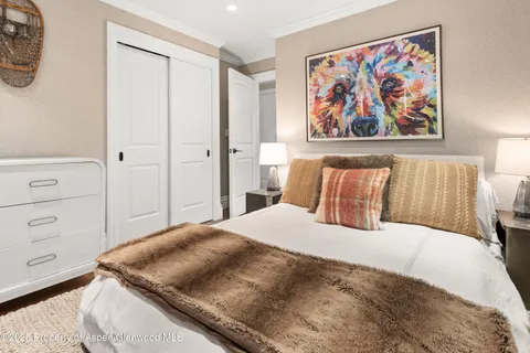 a bedroom with a bed and painting on the wall