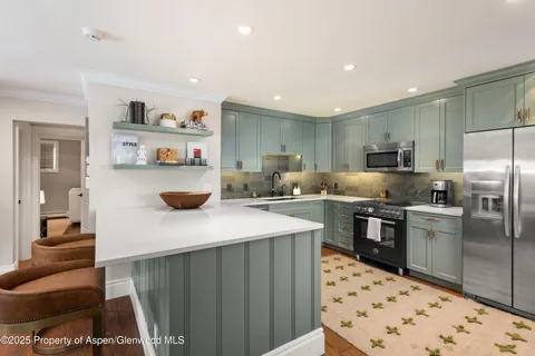 a kitchen with refrigerator and cabinets