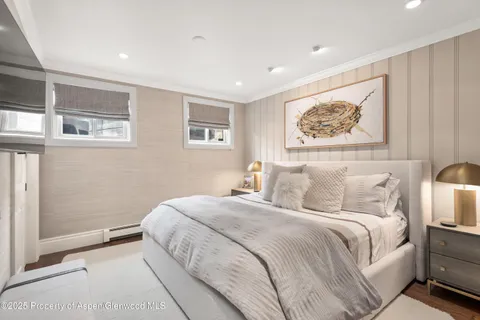 a bedroom with a bed and a painting on the wall