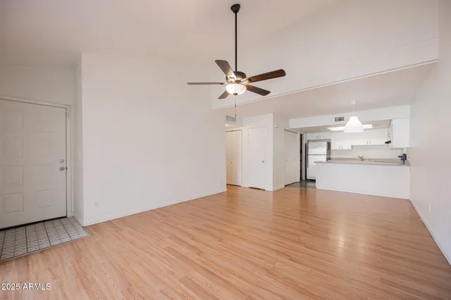 a view of an empty room with a window and wooden floor