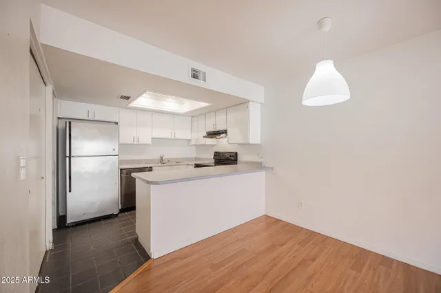 a kitchen with a refrigerator sink and cabinets