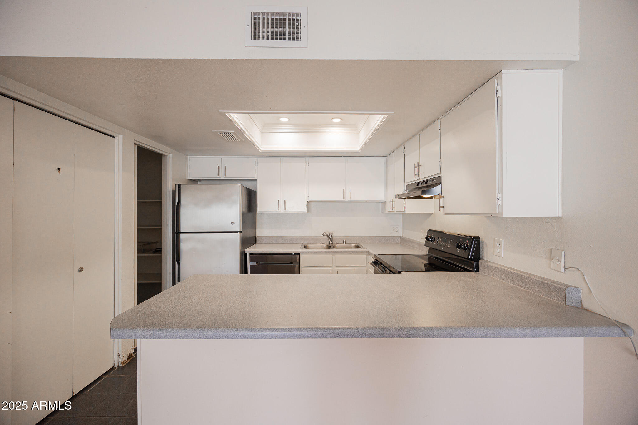 2141 East Kirkland Lane, Unit 4 Tempe, AZ 85281 - Photo 9 of 21 a kitchen with kitchen island a sink a refrigerator and white cabinets