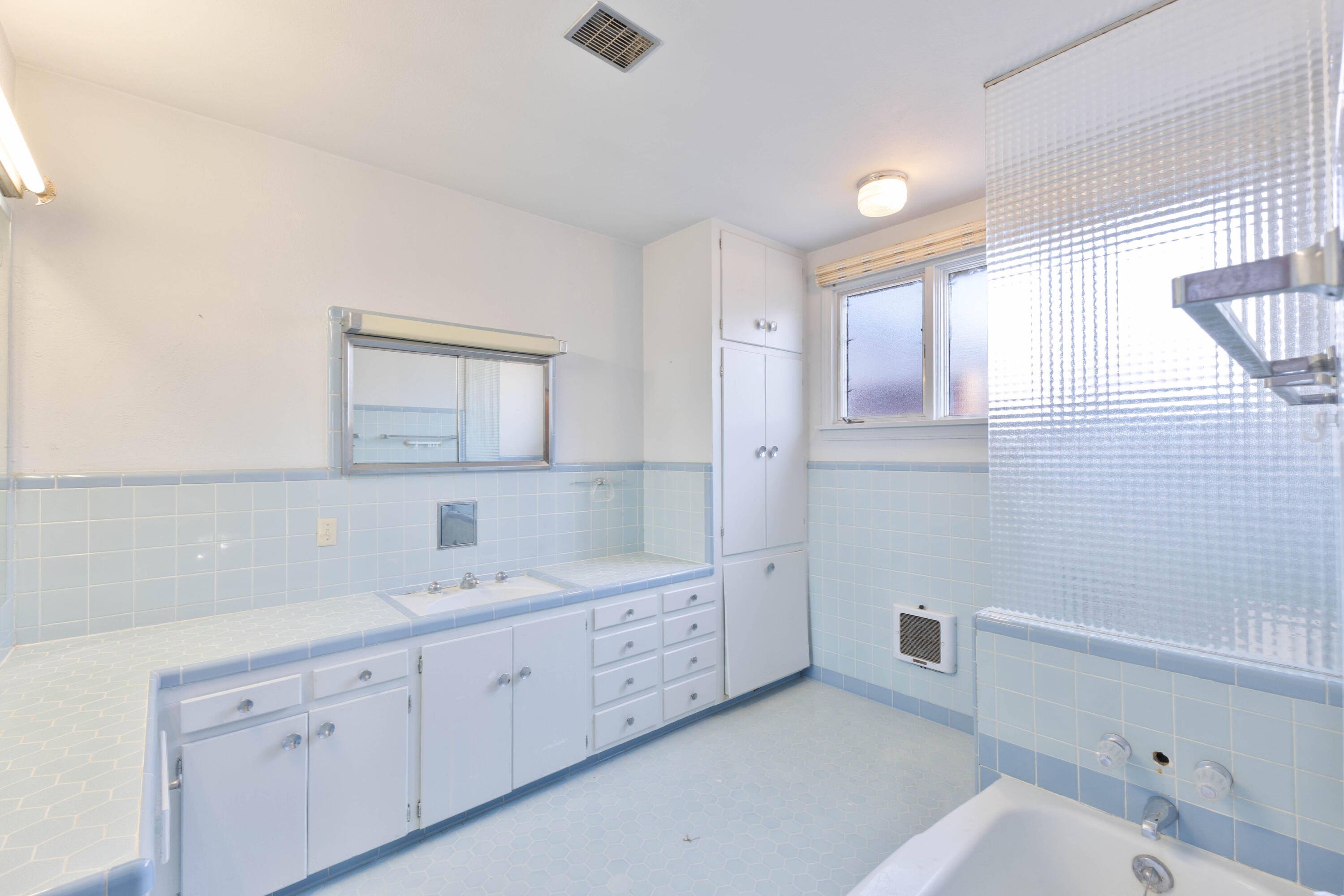 212 West 9th Street Plainview, TX 79072 - Photo 14 of 35 a spacious bathroom with a double vanity sink a mirror and a bathtub