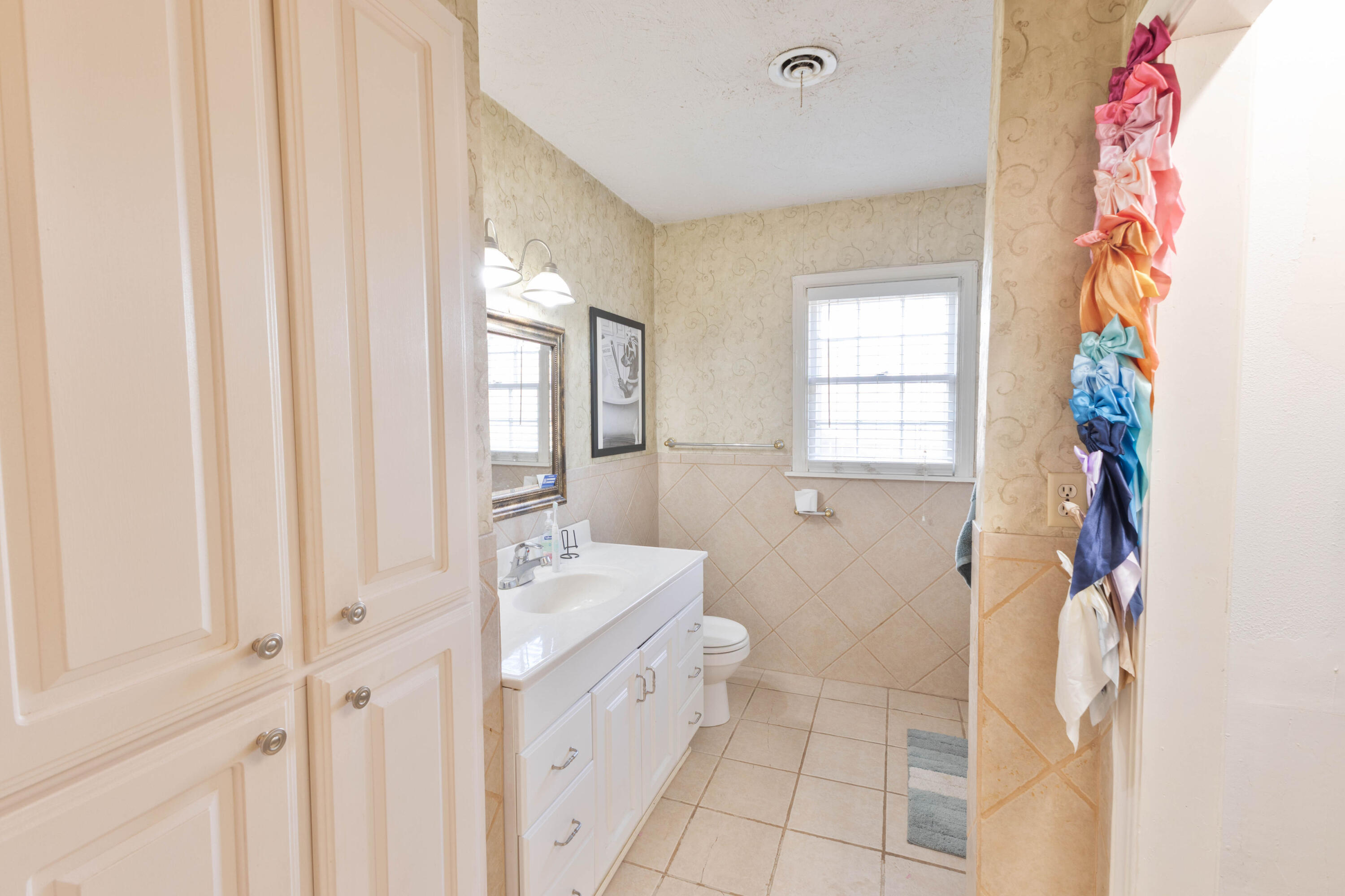 212 West 9th Street Plainview, TX 79072 - Photo 26 of 35 a bathroom with a sink a toilet and a window