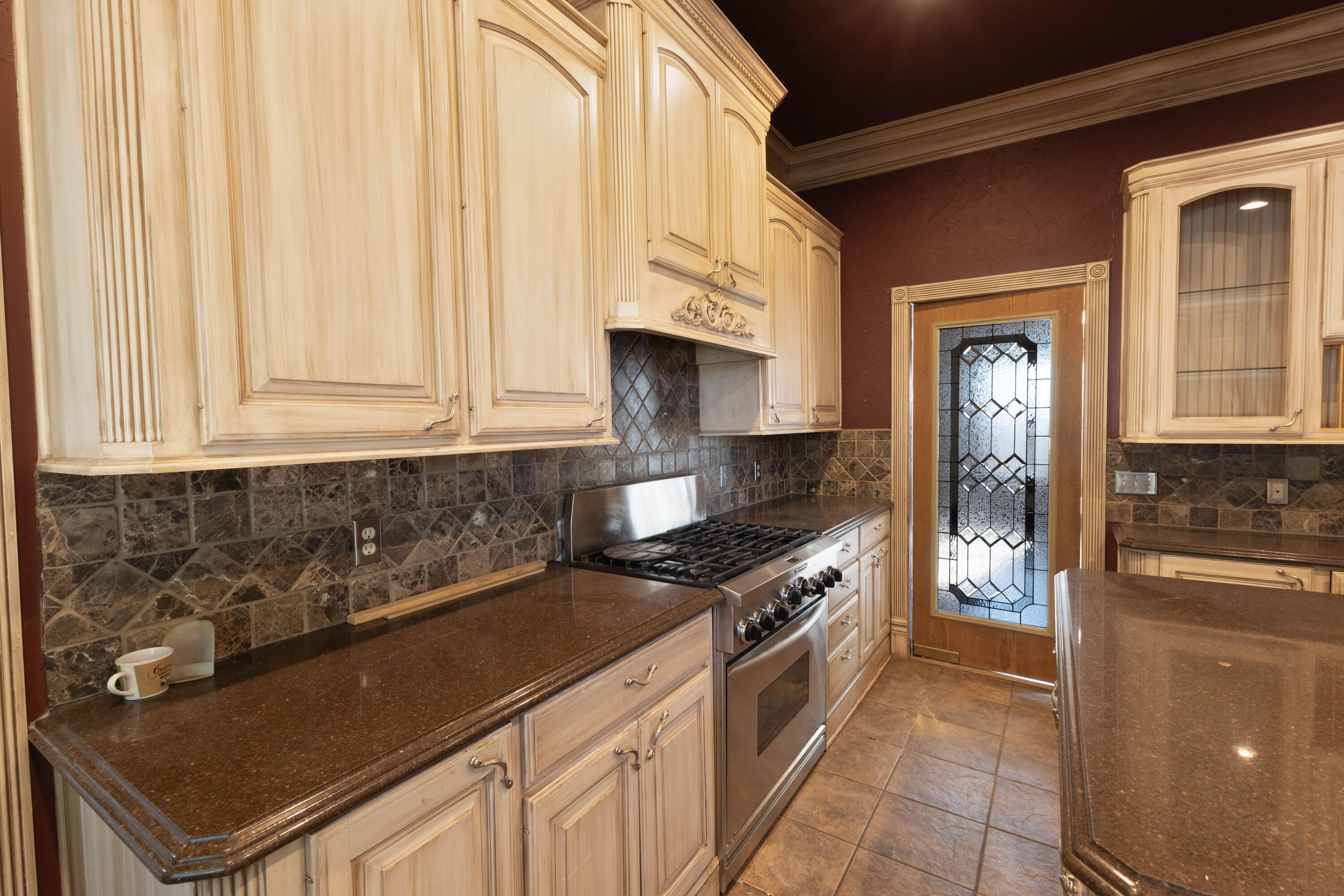 212 West 9th Street Plainview, TX 79072 - Photo 9 of 35 a kitchen with granite countertop a stove sink and cabinets