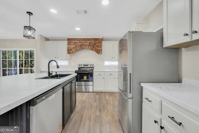 a kitchen with sink a refrigerator and cabinets