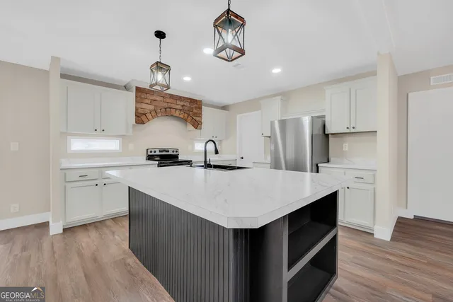 a kitchen with kitchen island a sink stainless steel appliances and cabinets