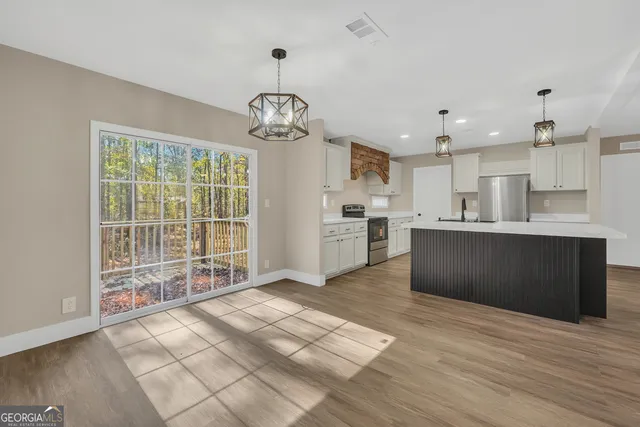 a view of kitchen with granite countertop cabinets and refrigerator