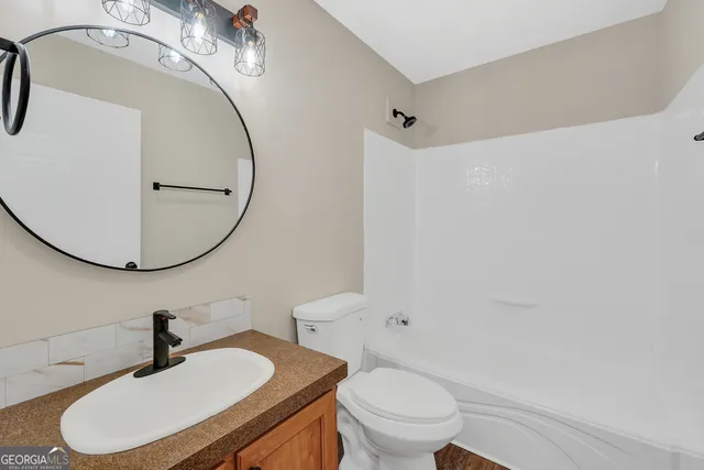 a bathroom with a sink a toilet and a mirror