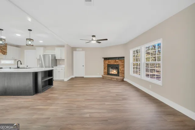 a view of an empty room with a kitchen and a window