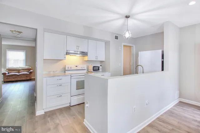a kitchen with a stove a refrigerator and a chandelier