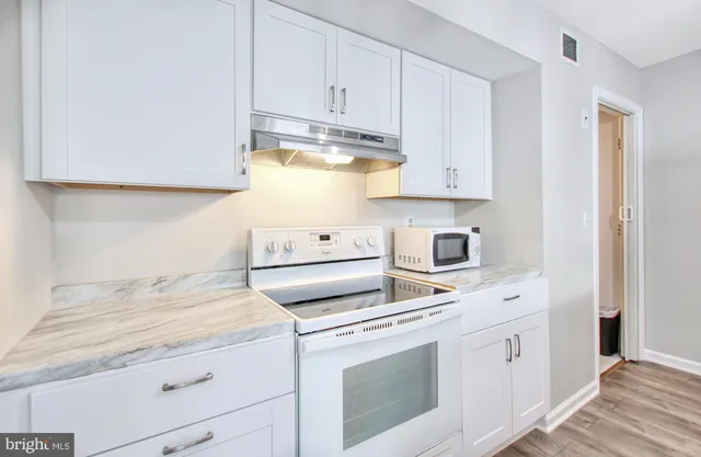 a kitchen with white cabinets and white appliances