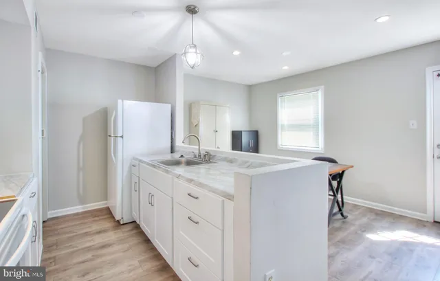 a kitchen with kitchen island a sink appliances and a counter top space