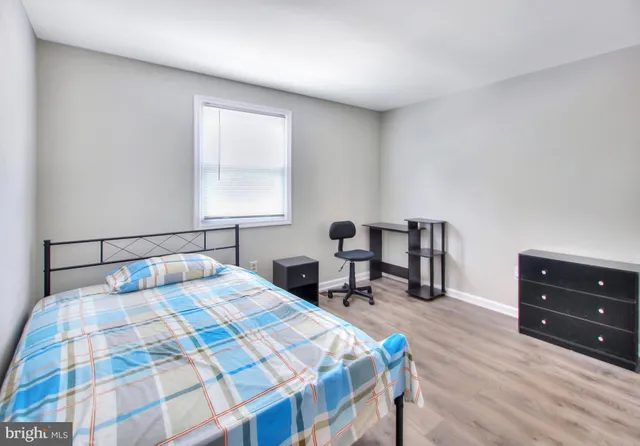 a bedroom with a bed a table and chair