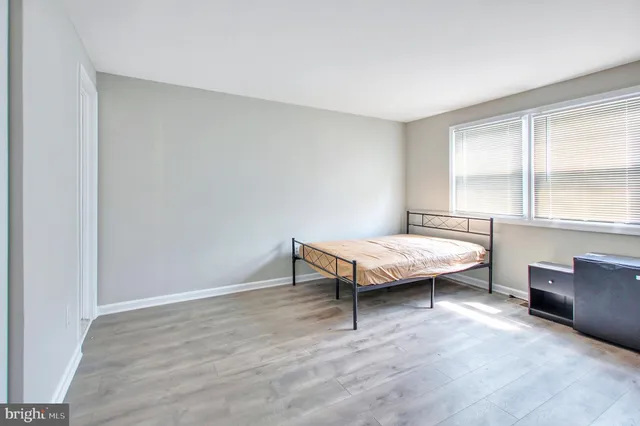 a spacious bedroom with a bed and large windows