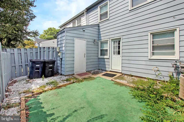 a view of a backyard with table and chairs and wooden fence
