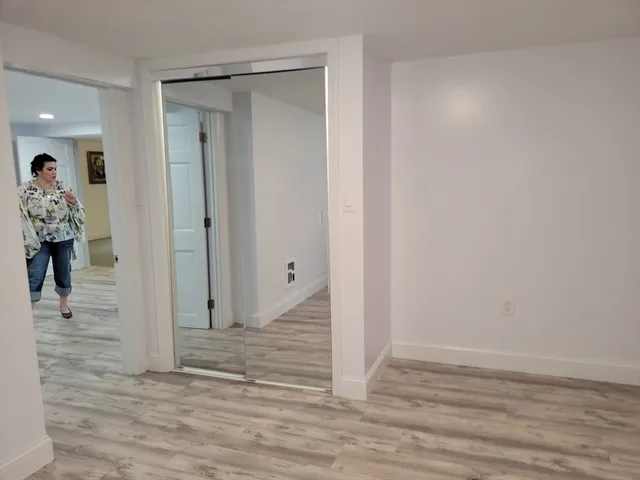 a view of a hallway with wooden floor and closet