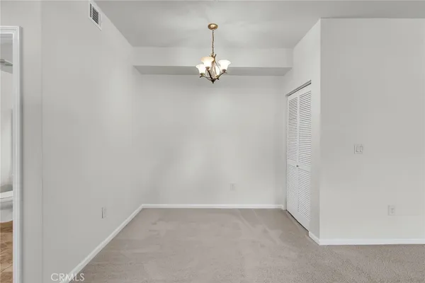 an empty room with a ceiling fan and window