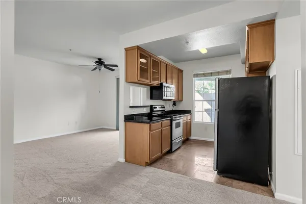 a kitchen with granite countertop a refrigerator and a stove top oven