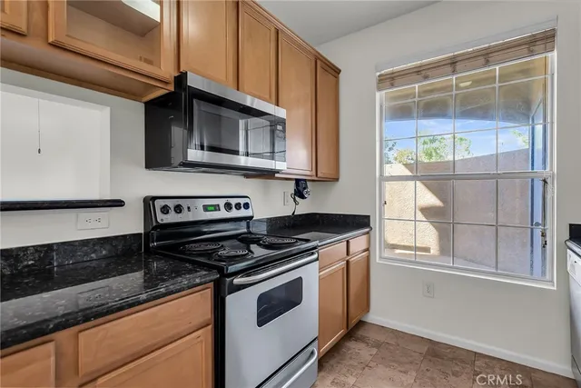 a kitchen with stainless steel appliances granite countertop a stove and a microwave
