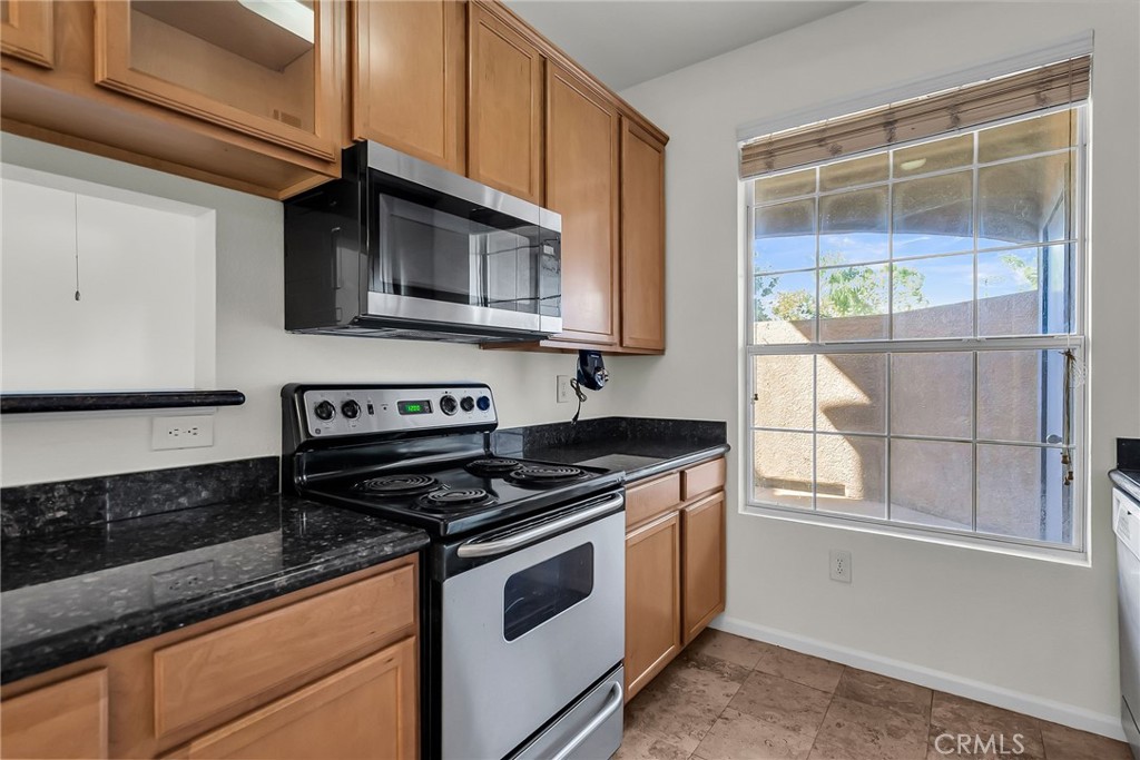 375 Central Avenue, Unit 83 Riverside, CA 92507 - Photo 5 of 29 a kitchen with stainless steel appliances granite countertop a stove and a microwave