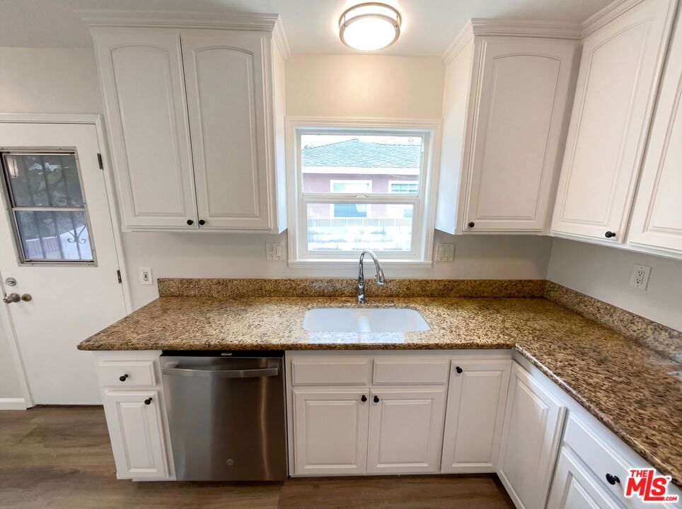 3237 Daisy Avenue Long Beach, CA 90806 - Photo 16 of 28 a kitchen with granite countertop cabinets sink and window