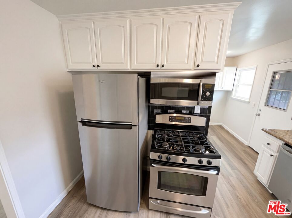 3237 Daisy Avenue Long Beach, CA 90806 - Photo 2 of 28 a kitchen with stainless steel appliances a stove and a refrigerator