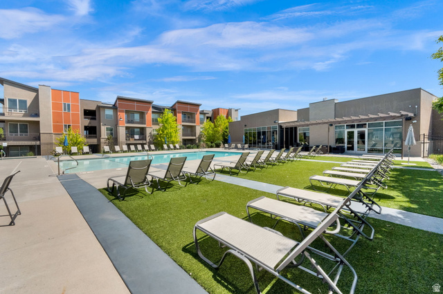 7713 Navarro View Court Midvale, UT 84047 - Photo 32 of 41 Expansive outdoor pool area featuring a rectangular swimming pool, surrounding concrete decking, and artificial turf lounge spaces