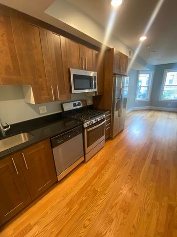 a kitchen with granite countertop a stove a sink and a microwave