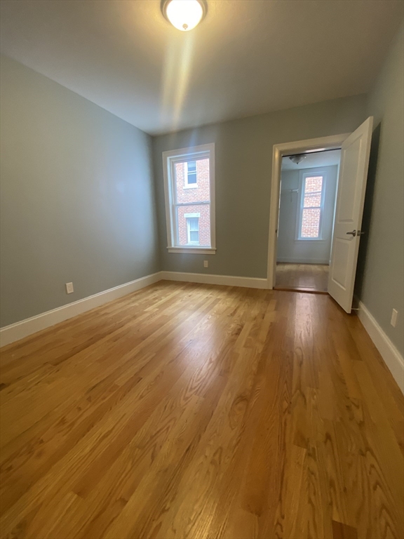 186 Kelton Street, Unit 2 Boston, MA 02134 - Photo 8 of 11 a view of empty room with wooden floor and fan