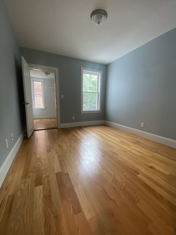 186 Kelton Street, Unit 2 Boston, MA 02134 - Photo 9 of 11 an empty room with wooden floor and windows