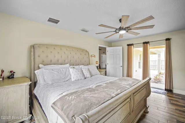 a bedroom with a large bed and a chandelier