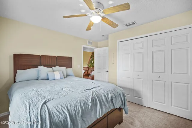 a bedroom with a bed and a ceiling fan