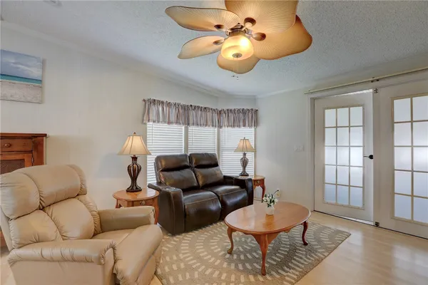 a living room with furniture a flat screen tv and a chandelier