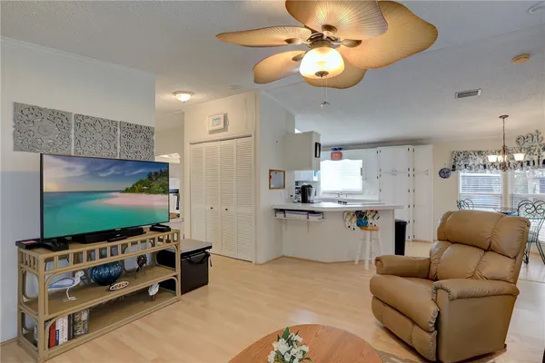 a kitchen that has a lot of white cabinets and stainless steel appliances