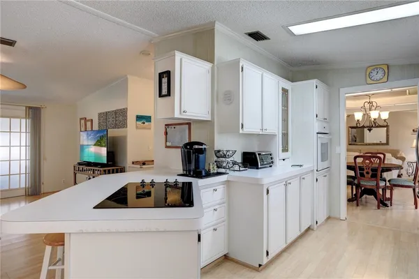 a kitchen with white cabinets and sink