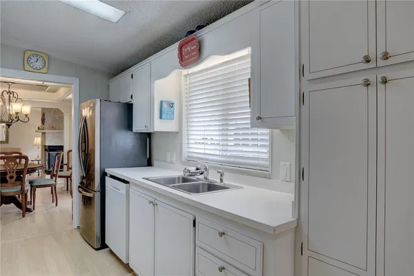 a kitchen with a sink cabinets and dining table chair